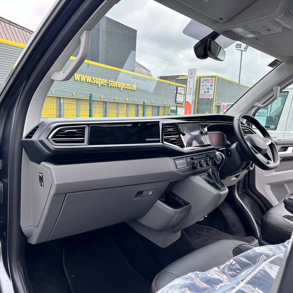 Car interior with dashboard and steering wheel, showing a Super-Storage UK building outside.